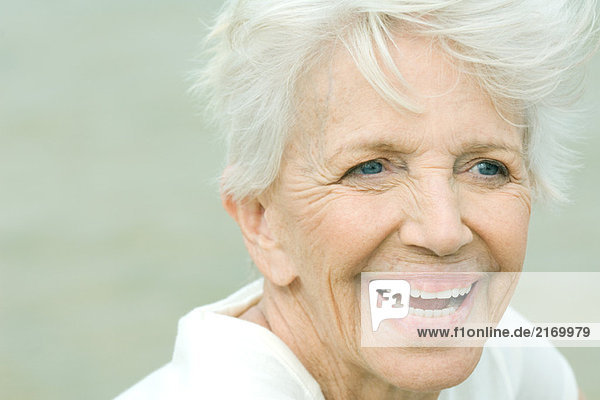 Senior woman smiling  looking away  portrait