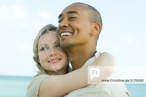 Couple embracing and smiling outdoors  close-up