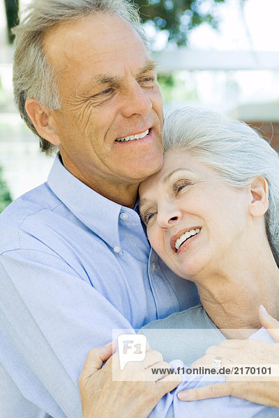 Mature couple embracing and smiling  close-up