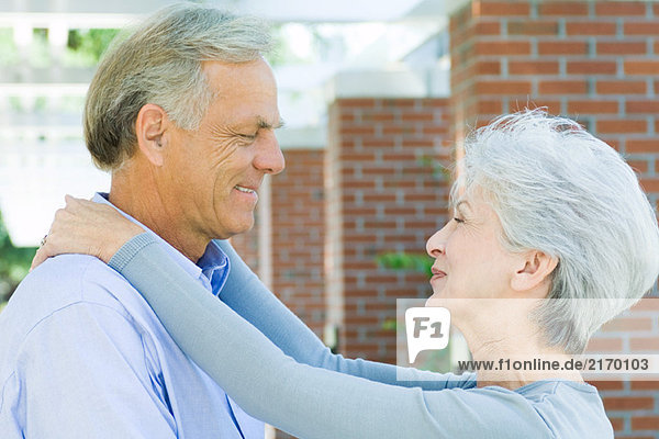 Mature couple smiling at each other  face to face  side view
