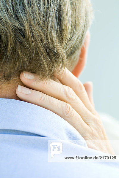 Cropped rear view of hand touching man's neck