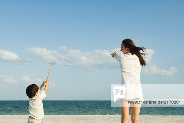 Frau und Junge fangen Wolken  Ozeanhorizont in der Ferne