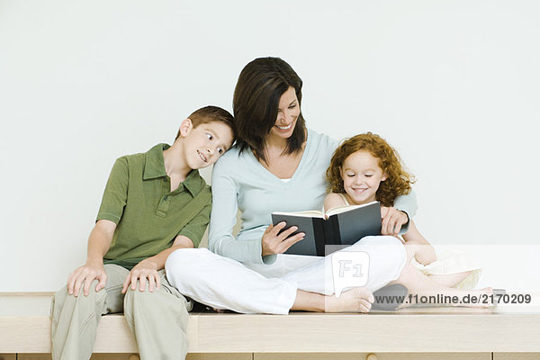 Mutter liest Buch für Sohn und Tochter