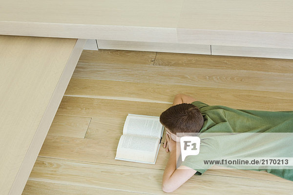 Junge auf dem Boden liegend  Lesebuch  Hochwinkelansicht