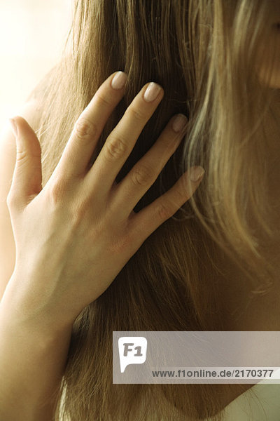 Junge Frau beim Berühren der Haare  abgeschnittene Ansicht der Hand