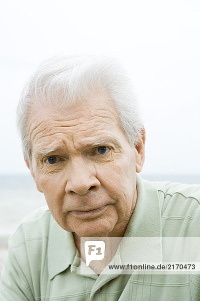 Senior man looking at camera  furrowing brow  portrait