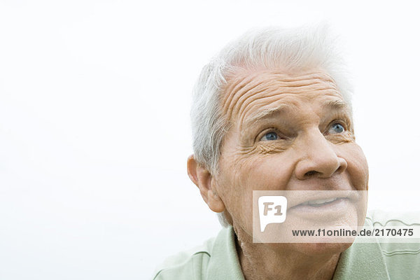 Senior man looking up  smiling  portrait