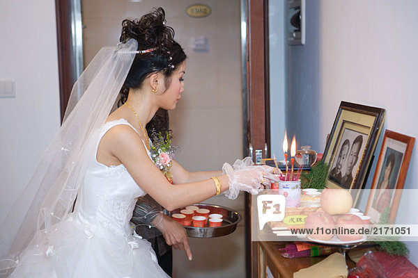 Chinesische Hochzeit  Braut nimmt Opfergabe an den Urheiligtum an