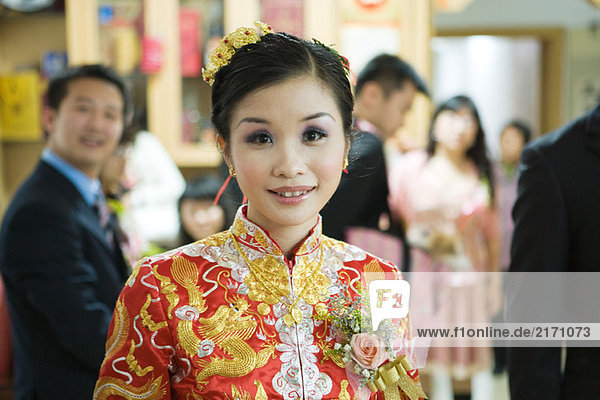 Braut in traditioneller chinesischer Kleidung  lächelnd vor der Kamera  Porträt