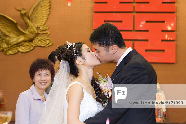 Braut und Bräutigam küssen  Seitenansicht