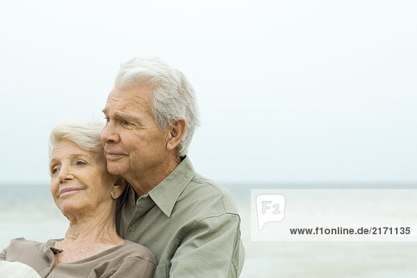 Senior Paar Wange an Wange im Freien  lächelnd und wegschauend  Nahaufnahme