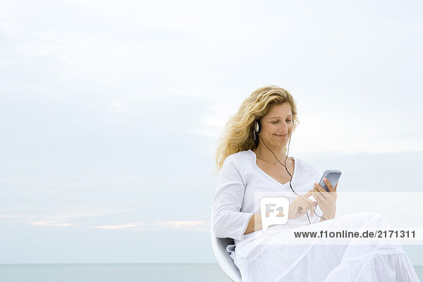 Frau hört MP3-Player  Ozeanhorizont im Hintergrund