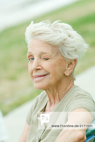 Seniorin blinzelt vor der Kamera  Porträt