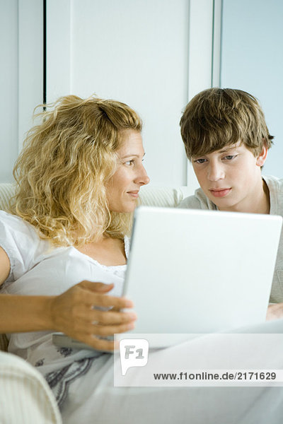 Frau und jugendlicher Sohn mit Laptop
