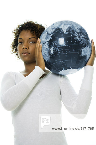 Junge Frau mit Globus auf der Schulter  Blick in die Kamera
