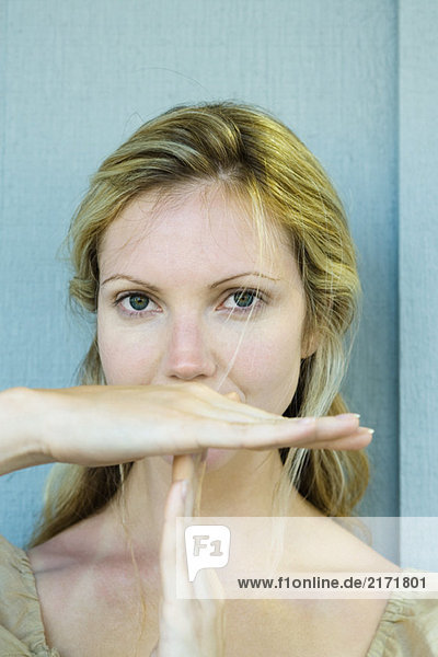 Woman making time out signal with hands  looking at camera