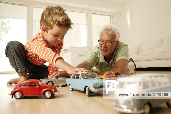 Opa und Enkel spielen mit Autos
