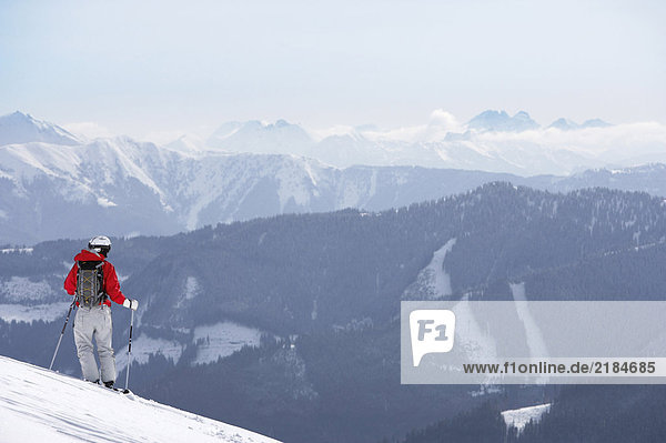 Österreich  Saalbach  Skifahrer auf der Piste stehend  Berge in der Ferne