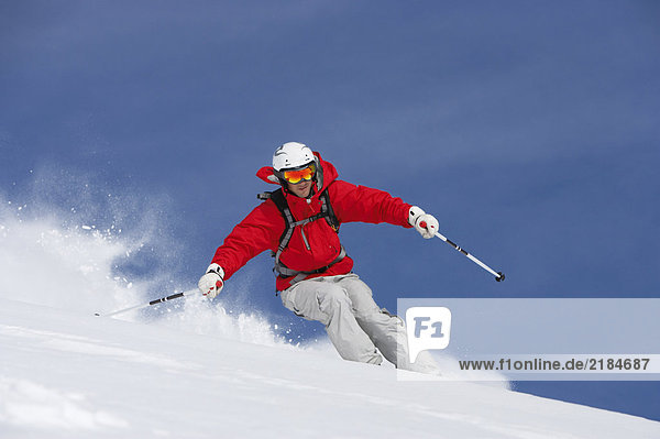 Mann beim Skifahren auf der schneebedeckten Piste  Blick in den tiefen Winkel