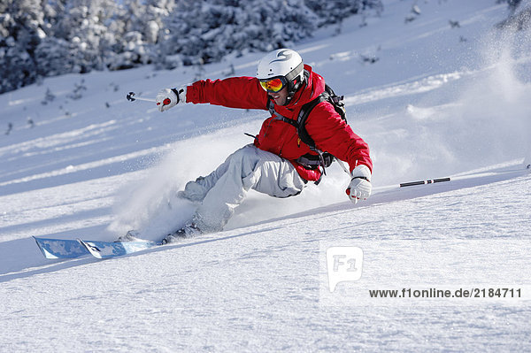 Austria  Saalbach  man skiing down slope  smiling