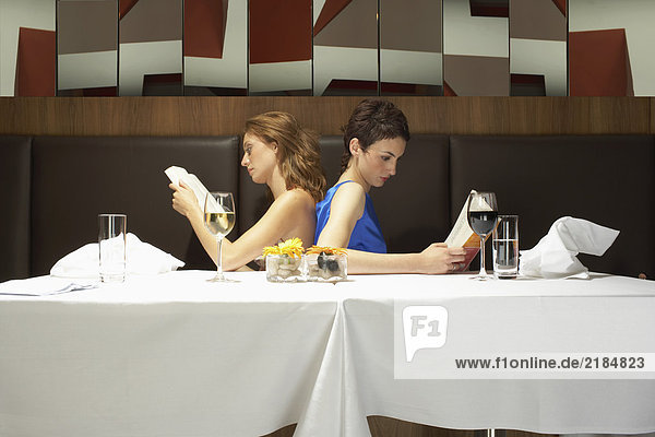 Zwei Frauen in einem Restaurant beim Lesen