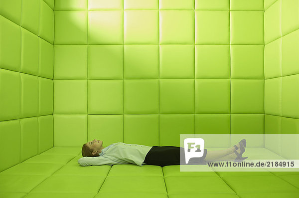 Frau in grüner Gummizelle liegend