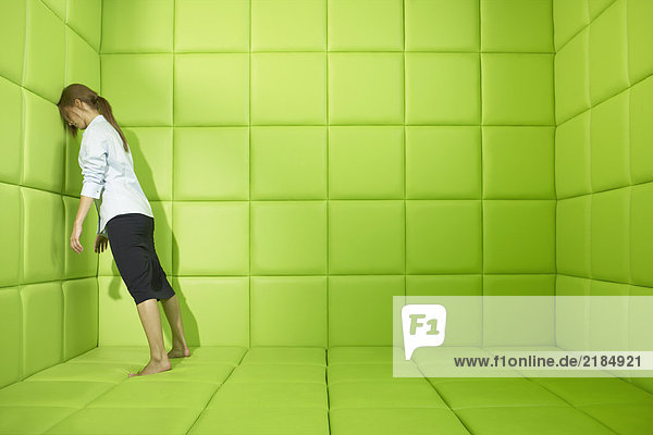 Frau drückt gegen die Wände der grünen Gummizelle