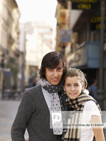 Young couple standing in street  smiling  portrait