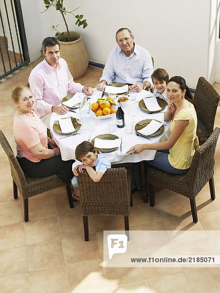 Mehrgenerationen-Familie beim Mittagessen auf der Terrasse  lächelnd  Portrait