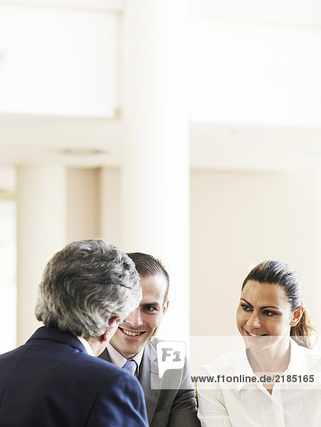 Two businessmen and woman in meeting  smiling