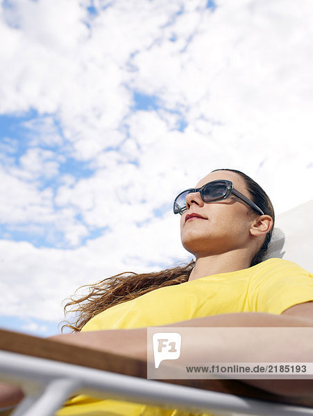 Woman wearing sunglasses relaxing in chair