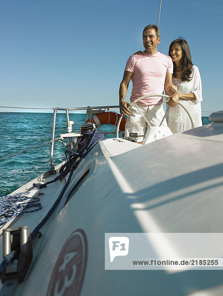 Erwachsenes Paar am Steuer der Yacht  lächelnd