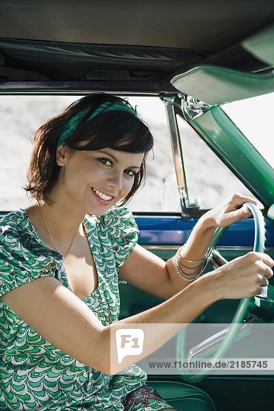 Woman in car smiling at camera.
