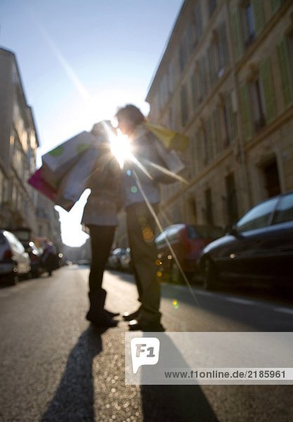 Young couple standing in street  Defocused (sun flare)