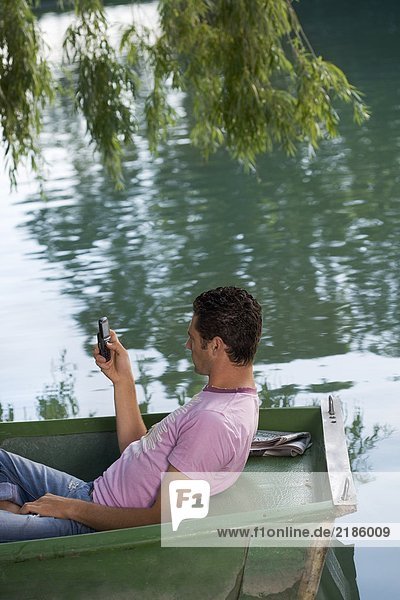 Man using a cell phone on boat