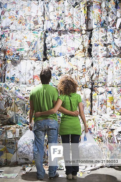 Mann und Frau in einer Recyclinganlage.