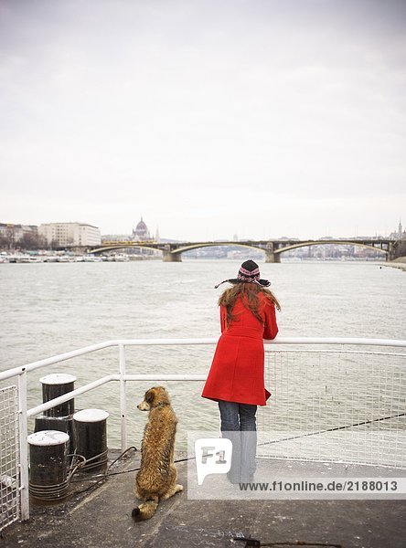 Hungary  River Danube  young woman on jetty with dog  rear view