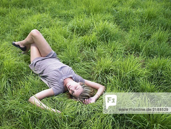 Frau entspannt sich auf der grünen Wiese.