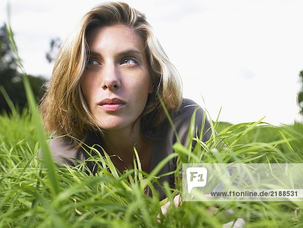 Woman laying in a green field portrait.