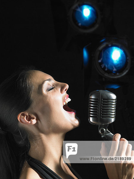 Woman singing into microphone.