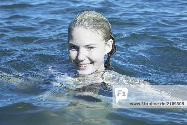 Junge Frau  die im Meer schwimmt.