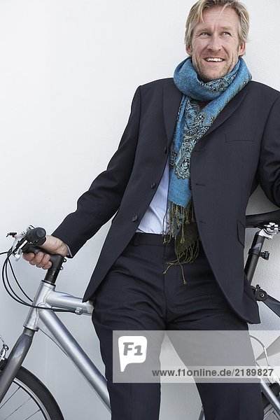 Businessman wearing extravagant scarf with bicycle.