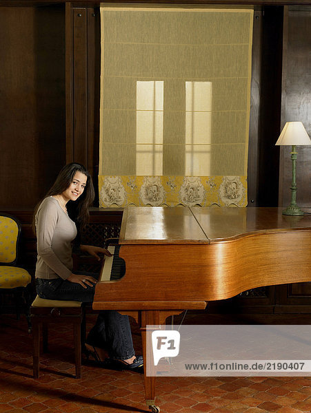 Junge Frau spielt Klavier  lächelnd  Portrait
