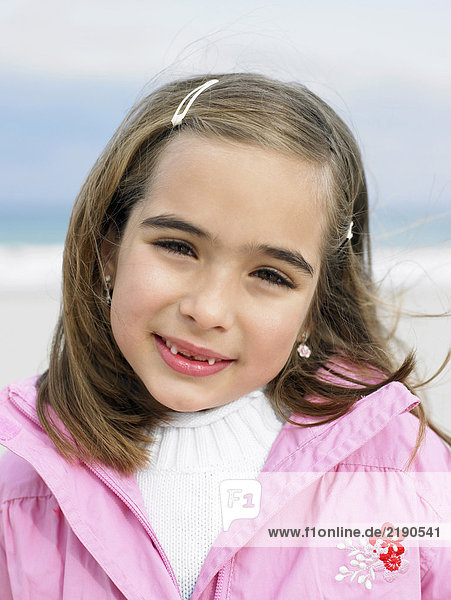 Girl (6-8) on beach smiling  portrait  close-up
