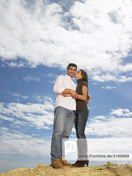 Auf einem Hügel posierendes Paar  Frau küsst die Wange eines Mannes  Alicante  Spanien