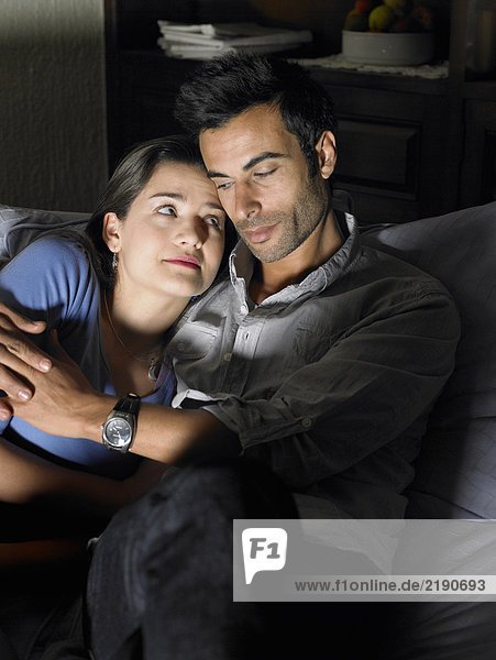 Junges Paar entspannt sich auf Sofa  Frau schaut Mann an