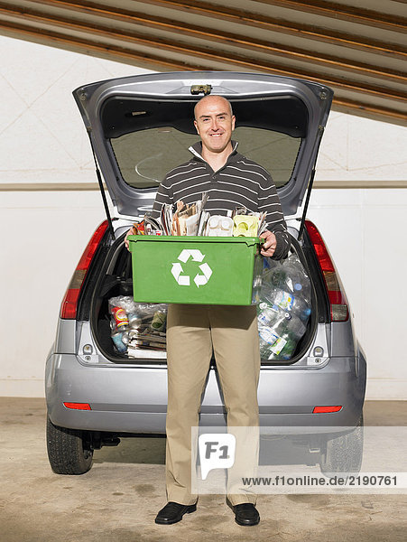 Mann steht vor der Kiste des Recyclings  lächelnd  Porträt