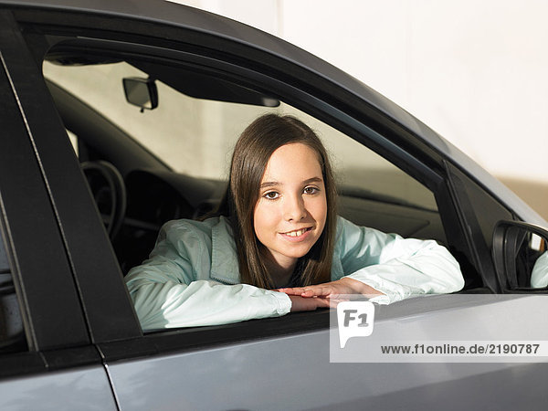 Girl (12-14) looking out of car window  smiling  portrait