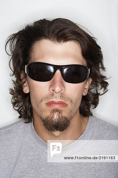 Junger Mann mit langen Haaren und Sonnenbrille