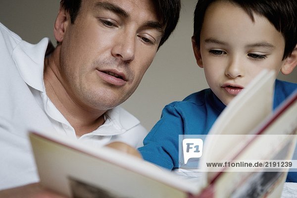 Portrait of a father and son reading.